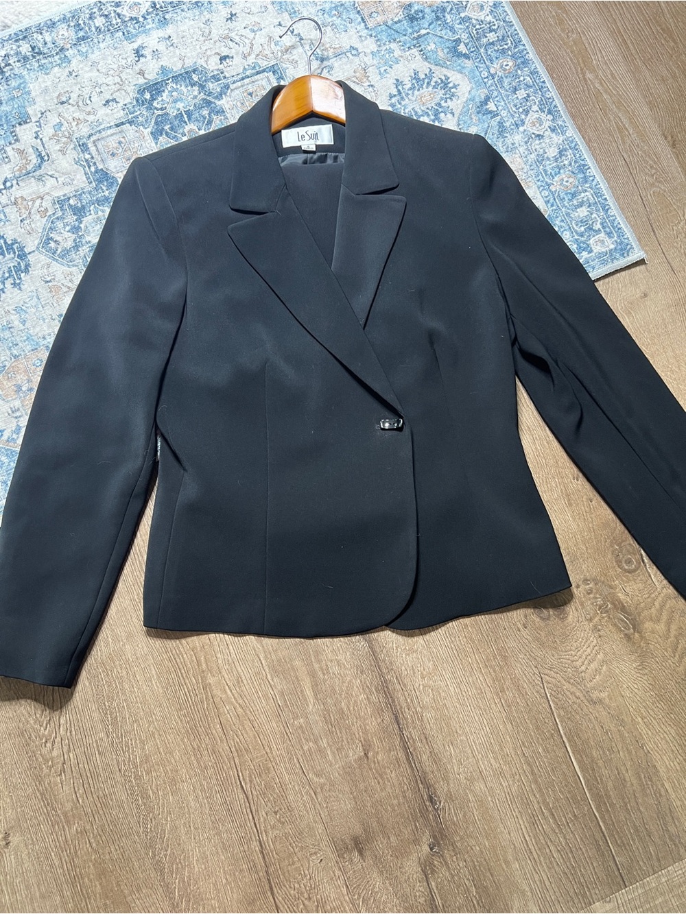 Le Suit blazer skirt set features a single-button closure on front and tailore